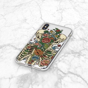 May include: A clear phone case with a colorful floral design featuring a skeleton with two skulls and a bird. The design is in a vintage style.