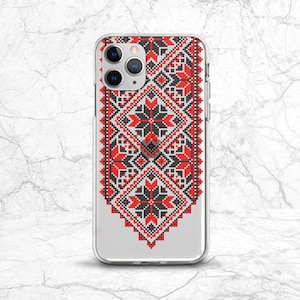 Puede incluir: Funda transparente para teléfono con un llamativo diseño geométrico en rojo, negro y blanco. El patrón recuerda al bordado tradicional, con motivos florales y de diamantes repetidos. Para un smartphone con múltiples lentes de cámara.