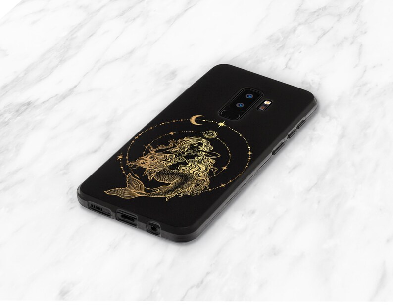 May include: Black phone case with a gold design of a mermaid with a crescent moon and stars.