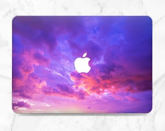 May include: Purple and pink laptop skin with a white apple logo and a cloudy sunset sky design.