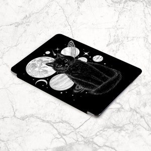 May include: Black and white illustration of a cat sitting on a black background with white planets and stars. The cat is looking directly at the viewer.