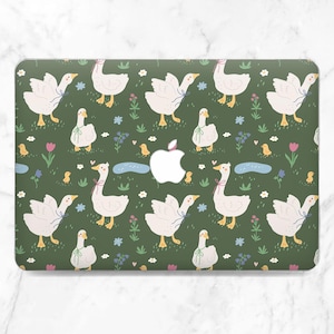 Puede incluir: Una funda para portátil con un patrón repetido de gansos blancos con lazos rosas, picos y patas amarillas, y pollitos sobre un fondo verde oscuro. El diseño incluye flores, estanques y el logotipo de Apple.