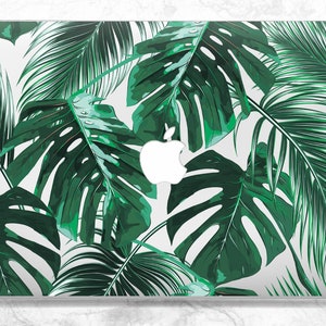 May include: A laptop skin with a tropical leaf pattern. The design features large green leaves with a white background. The Apple logo is visible in the center of the skin.