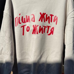 A fashionable sweatshirt with Пішла жити то життя will become your talisman, inspiring you to move forward and not give
