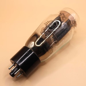 May include: A vintage vacuum tube with a clear glass bulb and a black base with metal pins. The tube has internal components visible through the glass and markings that read "61". The overall design is cylindrical.