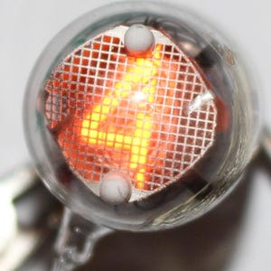 May include: A close-up of a clear glass bulb with a glowing orange number "4" inside. The number is displayed on a grid of small squares.
