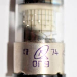 May include: A silver vacuum tube with a glass envelope and a black base. The tube has a grid structure visible inside and text printed on the base: "X1 74 069".