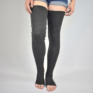 May include: Charcoal gray, over-the-knee leg warmers with a ribbed knit design. The leg warmers are open at the toes and extend up the thighs. The product is displayed against a plain, light gray background.