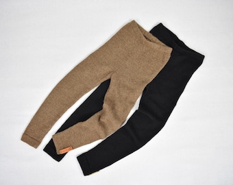 May include: A pair of leggings in solid brown and a pair of leggings in solid black. Both pairs feature a textured knit fabric, an elasticized waistband, and a small rectangular tan brand tag attached to the lower leg of the black pair.