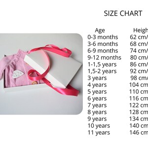 May include: A pink knitted cardigan with buttons in a white gift box with a pink ribbon. A size chart is shown with ages and corresponding heights in inches and centimeters.