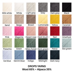 Puede incluir: Una carta de colores de DROPS YARNS con 29 muestras cuadradas de lana y alpaca. Los colores incluyen blanco leche, blanco, gris claro, gris, gris oscuro, negro, arena, beige, marr&oacute;n, limonada, amarillo, caramelo, rosa, magenta, rosa desierto, rubor oscuro, rojo, amatista, pistacho, verde, bosque brumoso, verde oscuro, petr&oacute;leo, verde mar, azul hielo, azul mezclilla, &iacute;ndigo, medianoche y azul marino oscuro. Texto: DROPS YARNS Wool 65% + Alpaca 35%.