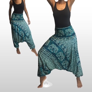 Puede incluir: Pantalones harén de color turquesa con un estampado de elefantes y geométrico. Los pantalones tienen un ajuste cómodo y holgado y una cintura elástica. La tela parece ligera. Los pantalones son mostrados en una persona.