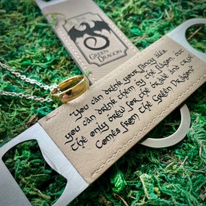 May include: A brown leather bottle opener with a silver metal opener. The bottle opener has the text "The Green Dragon" and a quote: "You can drink your fancy ales. You can drink them by the flagon, out the only brew for the true and true comes from The Green Dragon."