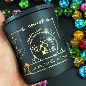 May include: Black candle jar with gold lettering that reads "Item Get Hidden Loot Candles" and "Secrets, Scrolls, & Tomes".