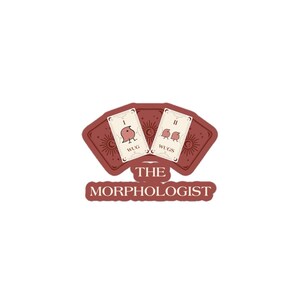 May include: A sticker featuring two tarot cards with bird illustrations and the words "WUG" and "WUGS". The cards are set against a maroon background with a sun design. The text "THE MORPHOLOGIST" is below the cards.