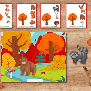 May include: A printable woodland animal matching game with a colorful autumn forest scene. The game includes a fox, raccoon, deer, bear, squirrel, rabbit, acorn, mushroom, and leaf.