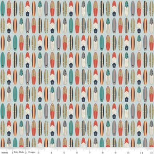 May include: A repeating pattern of surfboards in various colors, including red, teal, and beige, on a light blue background. The surfboards have different designs and are arranged vertically. The image includes the text "Riley Blake Designs" and inch measurements.