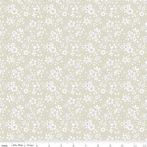 May include: A beige fabric with a white floral pattern. The fabric is covered in small white flowers with a light blue center.