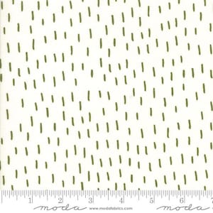May include: Off-white fabric with a repeating pattern of olive green dashes. The dashes are evenly spaced and create a textured appearance. The fabric has a ruler printed along the bottom edge, with the word "moda" printed in a script font.