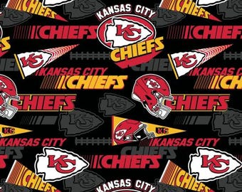 May include: A black and red fabric with a repeating pattern of the Kansas City Chiefs logo, the team name, and the words "Kansas City".