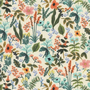 May include: A floral pattern featuring a variety of colorful flowers and foliage on a cream background. The design includes orange, pink, and blue flowers, along with green leaves and stems, creating a vibrant and detailed botanical print.