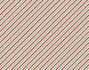 May include: A fabric with a diagonal stripe pattern in red, green, and white. The stripes are evenly spaced and run across the fabric. The image includes a ruler in inches along the bottom edge. The text "Riley Blake Designs" is also visible.