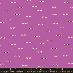 May include: A purple fabric featuring a repeating pattern of scattered pairs of eyes with white sclera and yellow irises. A black ruler at the bottom edge displays measurements from 1 to 7 inches and the text RUBY STAR SOCIETY.