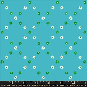 May include: A turquoise fabric with a repeating pattern of white and green daisies arranged in diagonal rows. The daisies have white petals and green centers. The bottom of the fabric has a black ruler with the text "RUBY STAR SOCIETY".
