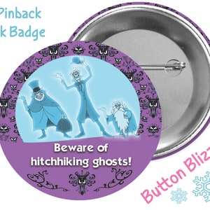 May include: A 3-inch pinback park badge featuring the Haunted Mansion ghosts from Disney. The badge is purple with a white background and features the text "Beware of hitchhiking ghosts!"