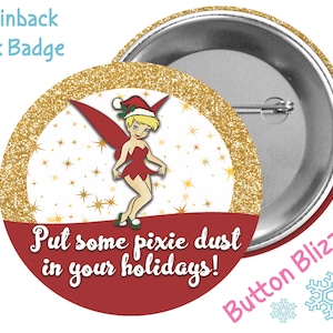 May include: A 3-inch pinback button with a gold glitter background and a red border. The button features a cartoon image of Tinkerbell with a red dress and a Santa hat. The text "Put some pixie dust in your holidays!" is printed in white on the button. The back of the button is silver.