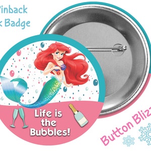 May include: A 3-inch pinback park badge featuring Ariel, the Little Mermaid, with a pink and blue background. The text "Life is the Bubbles!" is printed on the badge.