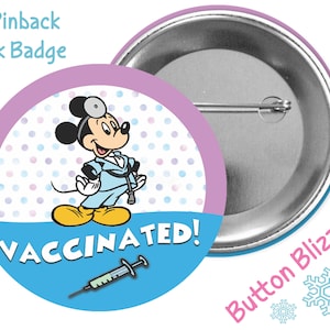 May include: A 3-inch pinback button featuring Mickey Mouse dressed as a doctor with a stethoscope. The button has a blue background with white polka dots and the text "VACCINATED!" with a syringe underneath. The button is surrounded by a pink border.