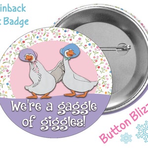 May include: A 3-inch pinback button with a pink and purple background. The button features two cartoon geese wearing hats and the text "We're a gaggle of giggles!"