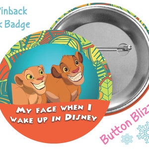 May include: A 3-inch pinback button with a colorful design featuring two cartoon lions. The lions are smiling and the text "MY FACE WHEN I WAKE UP IN DISNEY" is printed on the button. The button is a park badge.