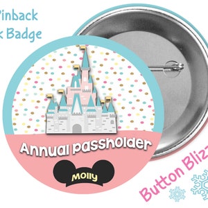 May include: A 3-inch pinback park badge with a pink and blue castle design. The badge has a pink background with white polka dots and gold glitter. The text "Annual Passholder" is written in black letters. A black Mickey Mouse head with the name "Molly" is at the bottom of the badge.