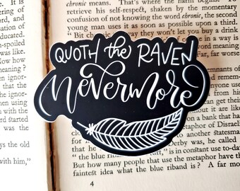 May include: Black and white sticker with the text "Quoth the Raven Nevermore" in a stylized font. The sticker features a white feather design with a black background.