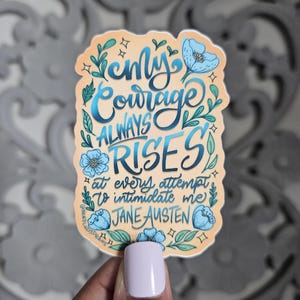 May include: A sticker with a quote from Jane Austen, featuring the text "My courage always rises at every attempt to intimidate me." The design includes blue floral accents and a light orange background.