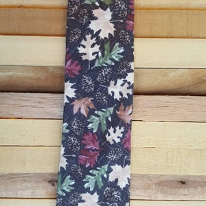 Falling Leaves and Pinecones.  Muted red, green, browns and tans.  Available in skinny, classic and bowties.  Youth sizes also!