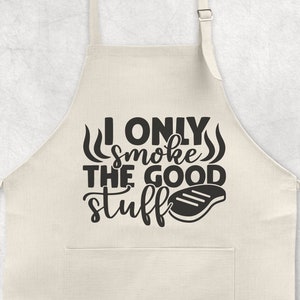 May include: A white cotton apron with a black graphic that reads "I only smoke the good stuff" and a black silhouette of a grilled steak.