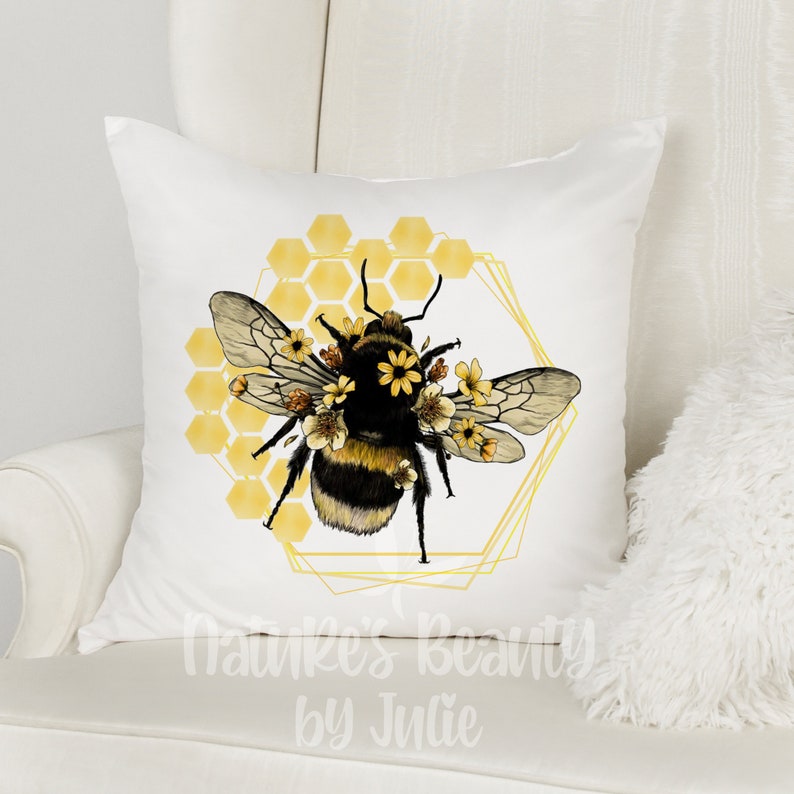 May include: White pillow with a black and yellow bumblebee surrounded by yellow flowers and a gold honeycomb design. The text "Nature's Beauty by Julie" is at the bottom of the pillow.