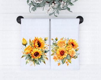 May include: Two white kitchen towels with a floral design featuring sunflowers and yellow roses. The towels are hanging on a black towel rack.