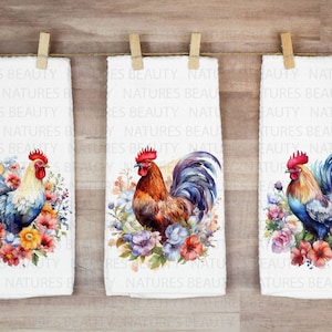 May include: Three white kitchen towels with a watercolor design of a rooster surrounded by flowers. The rooster in the left towel is blue and white, the middle towel has a brown and white rooster, and the right towel has a blue and orange rooster.