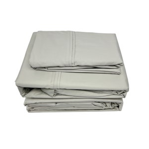 May include: A set of gray bed sheets folded neatly. The sheets are made of a soft, comfortable fabric and are perfect for a restful night's sleep.