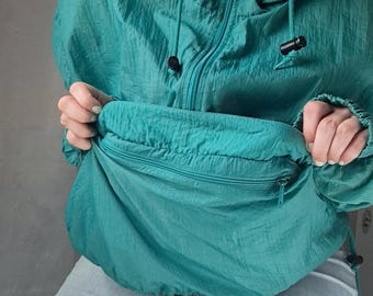May include: A teal blue hooded jacket with a zipper and a drawstring. The jacket has a large pocket on the front.