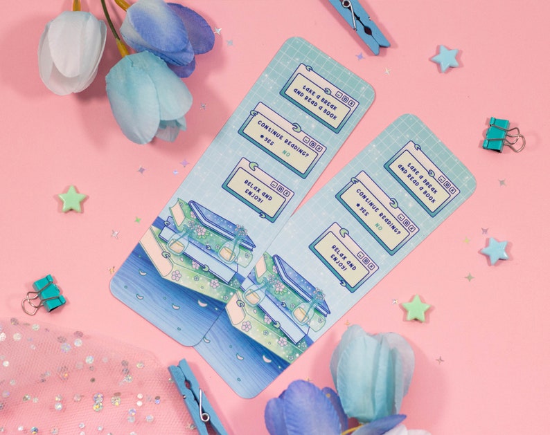 May include: Two blue and green bookmarks with a digital design. The bookmarks feature a stack of books with a moon and stars in the background. The text on the bookmarks reads "Take a break and read a book", "Continue reading?", "Relax and enjoy!"