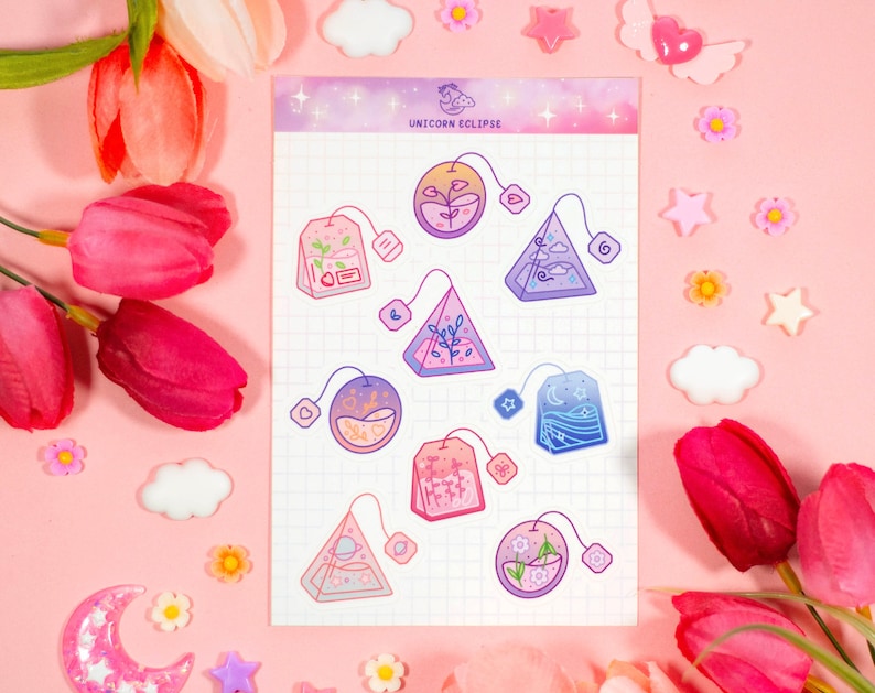 May include: A sheet of stickers featuring nine different tea bag designs. Each tea bag is illustrated with a different nature scene, including a forest, a mountain, a beach, and a starry sky. The stickers are printed on a white background with a grid pattern. The text "UNICORN ECLIPSE" is printed at the top of the sheet.