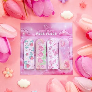 Può includere: Un set di quattro segnalibri rosa con disegni floreali, tra cui fragole, tulipani e fiori di ciliegio. I segnalibri sono confezionati su una carta rosa con il testo "Unicorn Eclipse Page Flags". Lo sfondo è rosa con fiori decorativi.