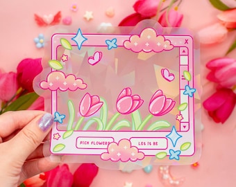 Può includere: Un adesivo olografico con uno schema di colori rosa, blu e verde. L'adesivo presenta uno schermo del computer con una nuvola, stelle e tulipani. Il testo sull'adesivo recita "Pick Flowers" e "Let It Be".
