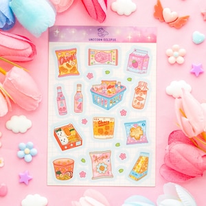 Könnte beinhalten: Ein Bogen mit bunten Aufklebern mit verschiedenen Lebensmitteln wie Chips, Milchkartons und Ramen. Die Aufkleber haben einen niedlichen, cartoonartigen Stil mit Pastellfarben und sind auf einem rosa Hintergrund mit dekorativen Blumen und Wolken angeordnet.