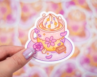 May include: A pink and yellow cartoon mug with a white swirl of whipped cream and a chocolate bar on a pink saucer with white glitter.